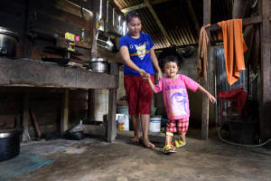 Selma with her mum in the kitchen. With the aid of her leg splints (funded by LF) Selma is now able to walk.