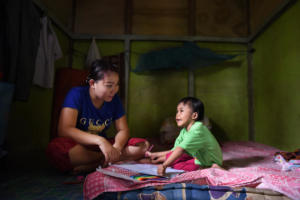 Selma and her mum Acu in the bedroom. Here Selma likes to write and play, as the mattras is soft she can also practice standing up. Acu is a caring mother who tries to make Selma as independent as possible by teachging her all she knows.