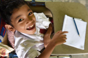 Moses is very happy to be able to go to school. Refused at first, his return with wheelchair made him extra motivated.