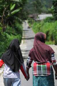 Tari and her Mum Wagiyem walking home from school. Theoretically speaking Tari is now able to walk to school on her own, but to prevent her from receiving any bullying, Wagiyem happily accompanies her daughter.